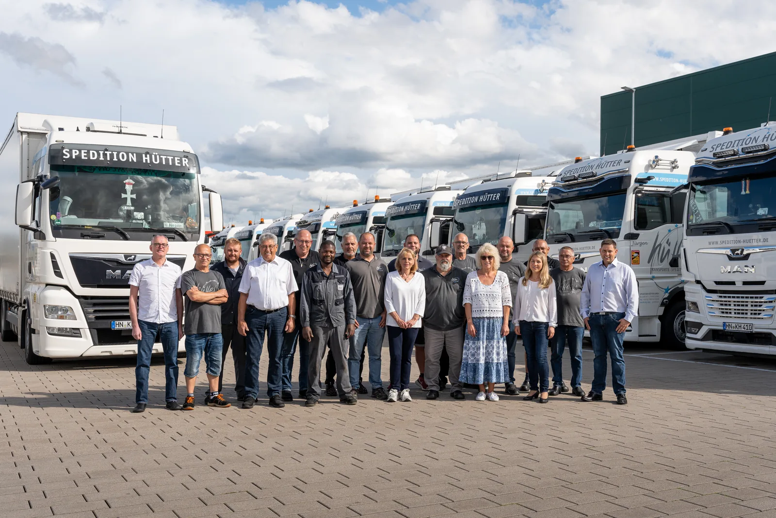 Das Team der Spedition Hütter vor dem eigenen Fuhrpark